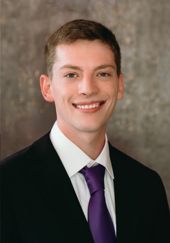 Anthony Dawley wearing a black suit and purple tie.