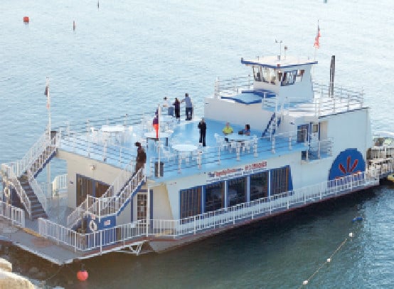 White passenger ferry carrying people on calm water