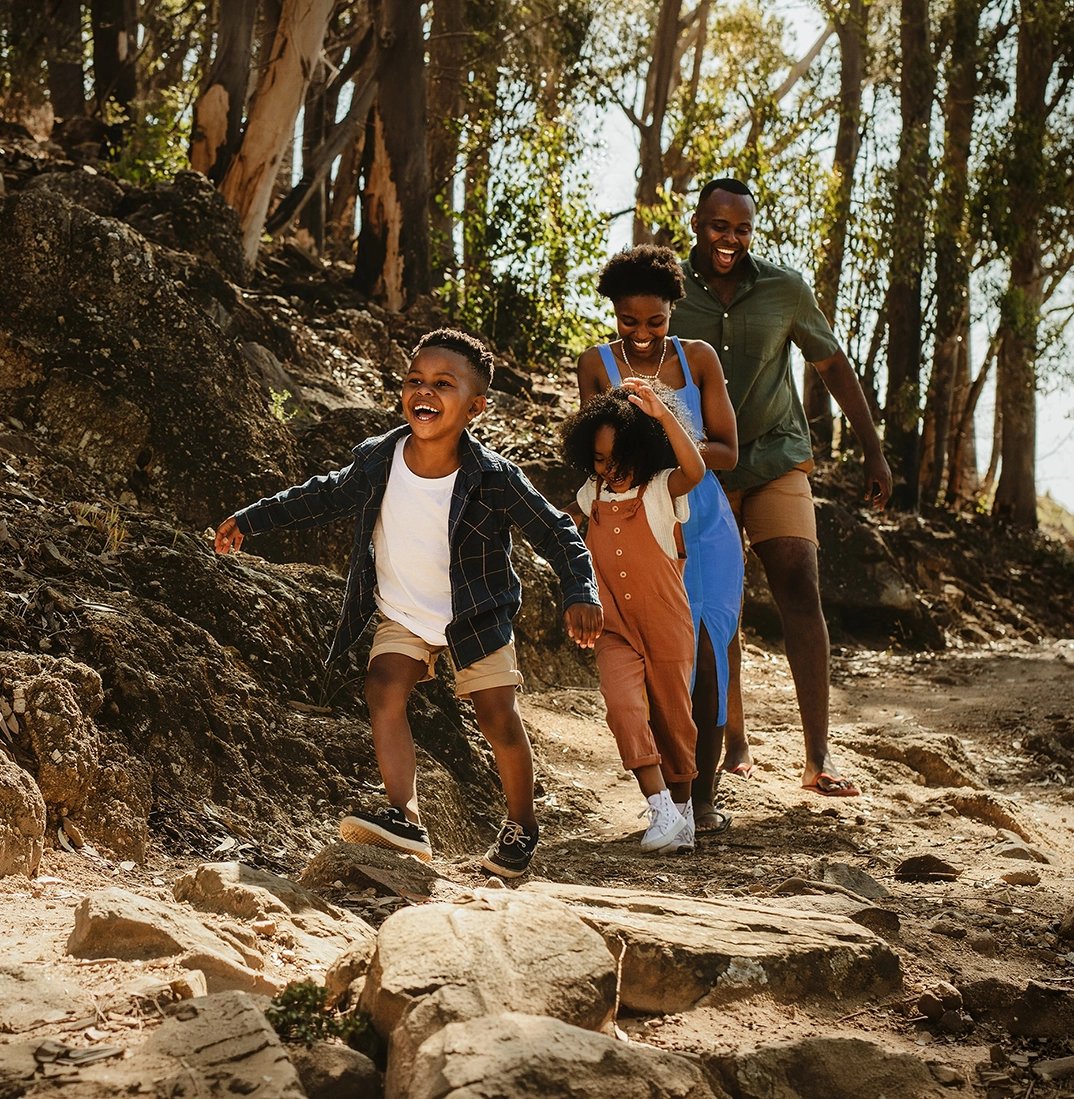 happy family in forest running down a ridge