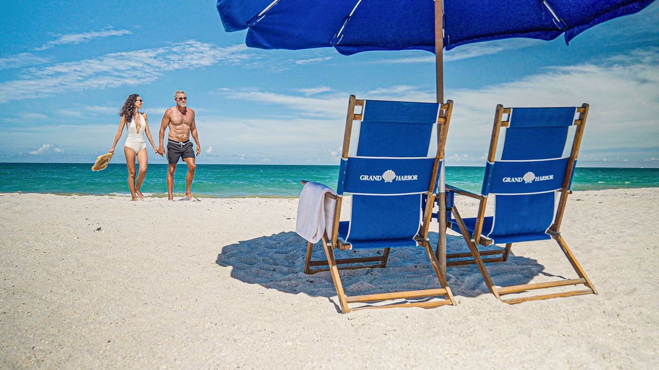 Couple walking the shoreline near the private Grand Harbor Beach Club, Vero Beach, Florida