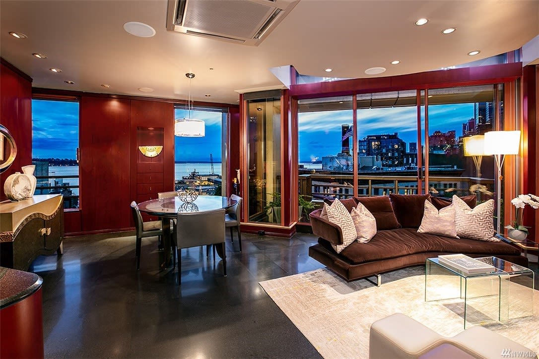 Luxurious condo interior with plush seating, ambient lighting, and stunning nighttime city views for upscale living.