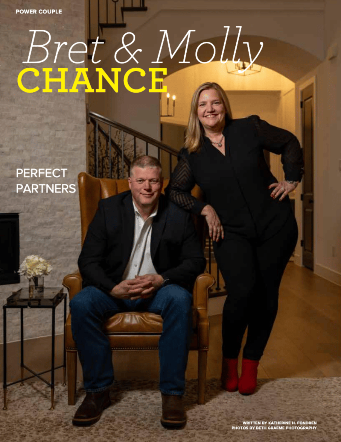 Bret and Molly Chance pose together in a warmly lit home interior.