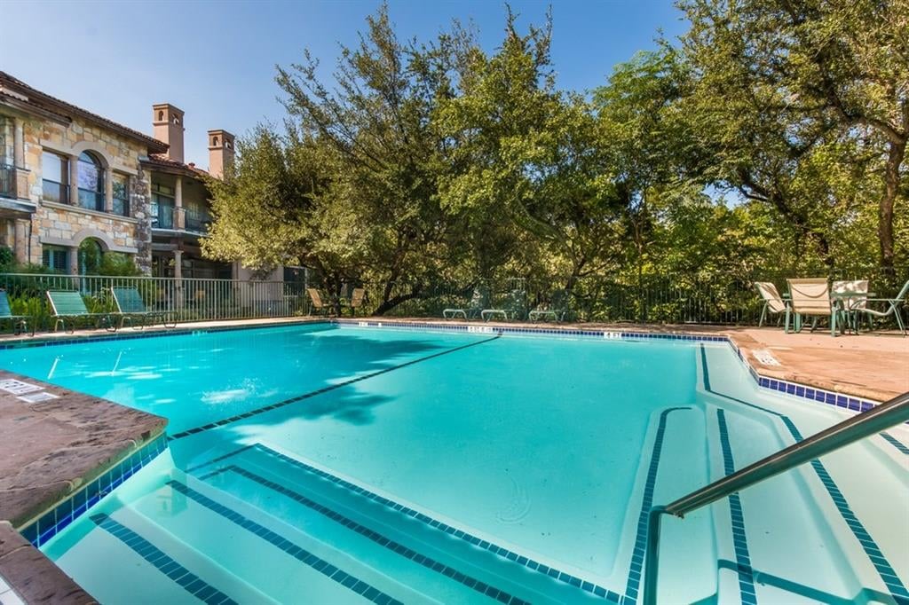 Community pool sun deck at Liberty Park Condominiums in West Lake Hills, Austin, with lounge seating and a shaded seating area.