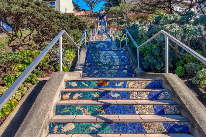 Colorful mosaic tile staircase with handrails surrounded by greenery in San Francisco