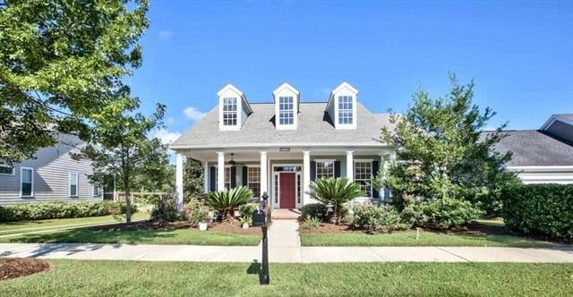 A charming home featuring a welcoming front porch and a well-maintained front yard.