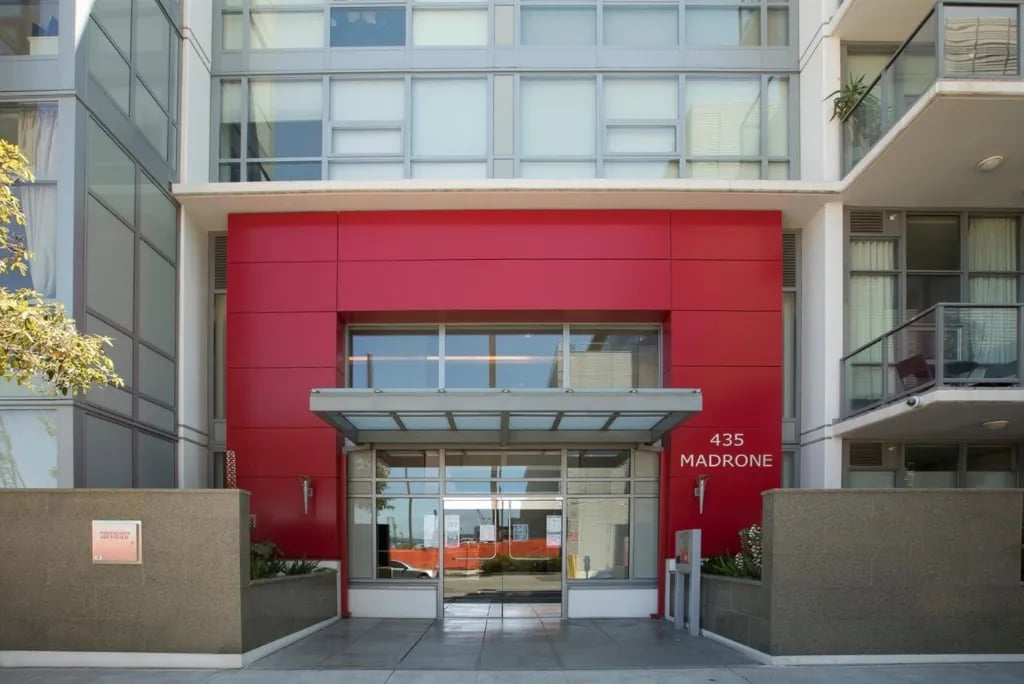 Madrone building entrance at 435 Madrone Street featuring distinctive red exterior panels, glass canopy, modern lobby design, and contemporary architectural details