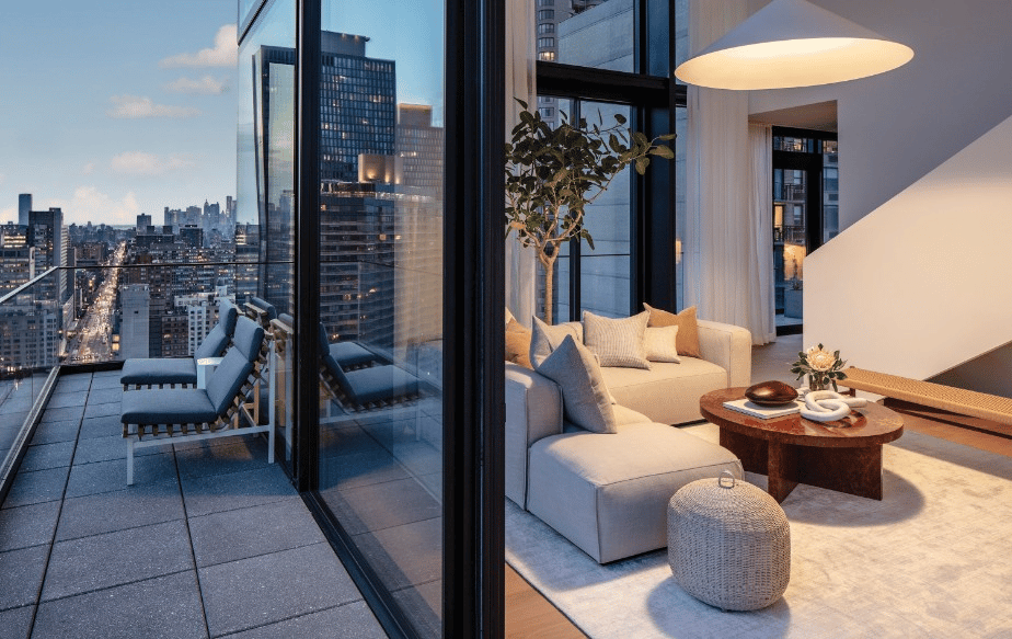High-rise living room with a pale sectional and a terrace overlooking the city at dusk.