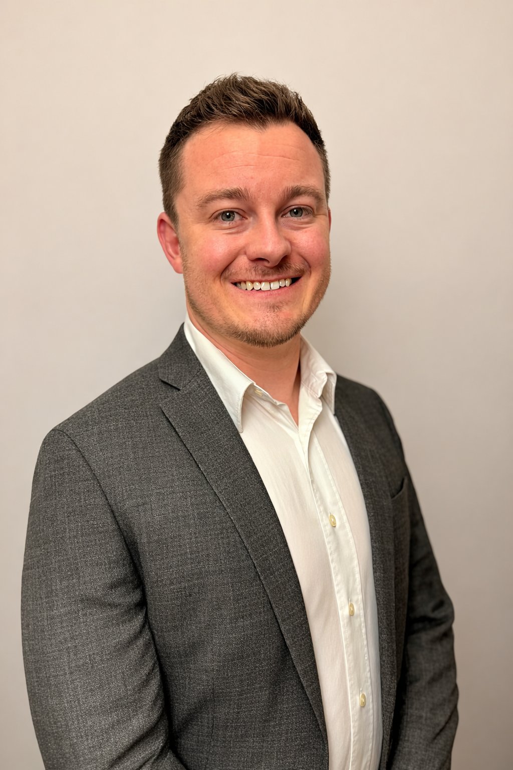 Kevin Black in a charcoal gray suit jacket and white shirt.