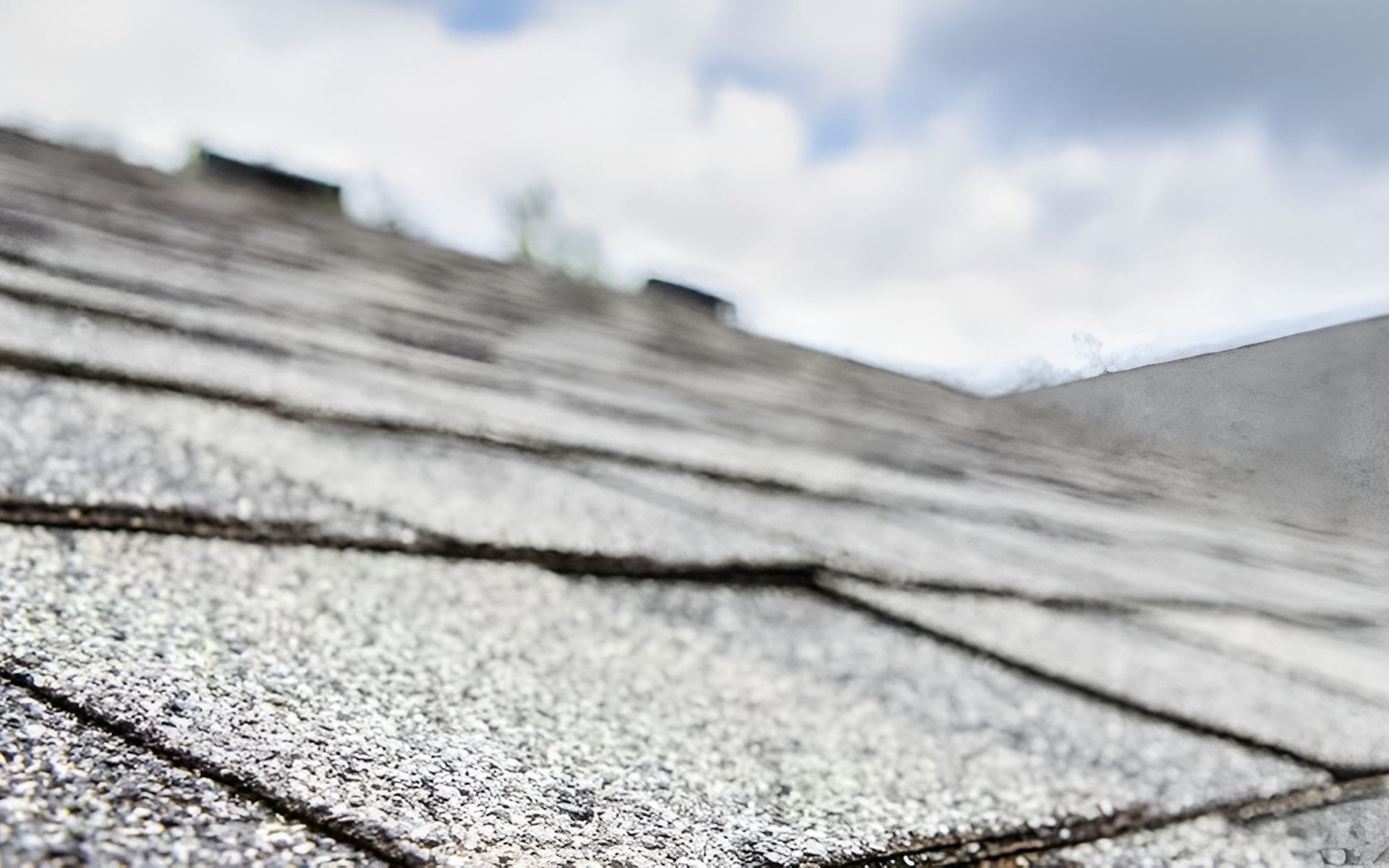Weathered gray asphalt shingles covering a sloping roof.