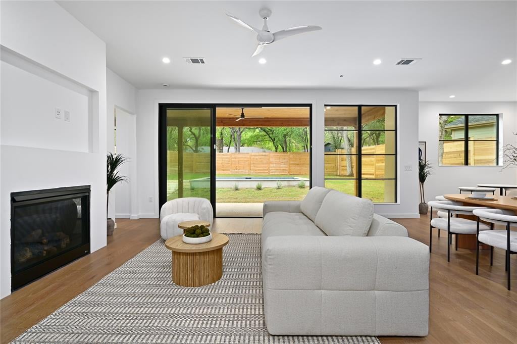 Living room at 2635 Barton Hills Dr, Austin, with a fireplace and sliding glass doors opening to the pool.