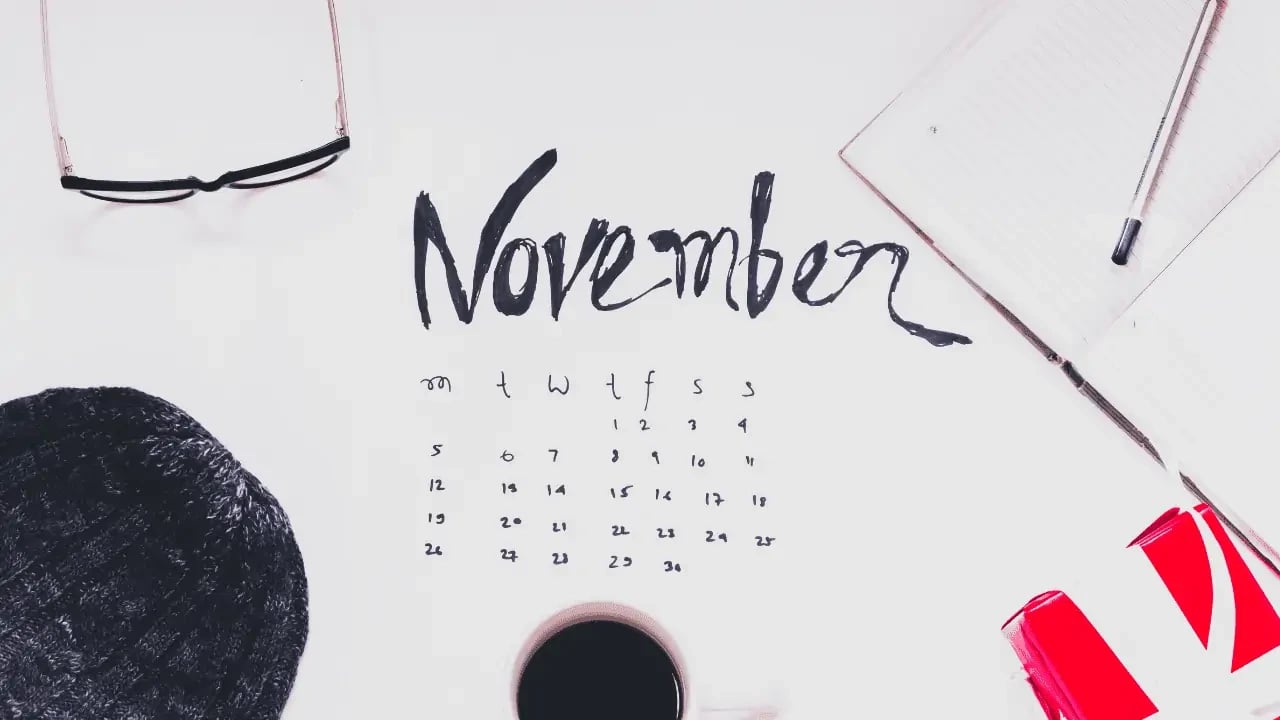 A calendar page for the month of November, with handwritten notes and a marker nearby. The scene suggests planning or organization for the month.