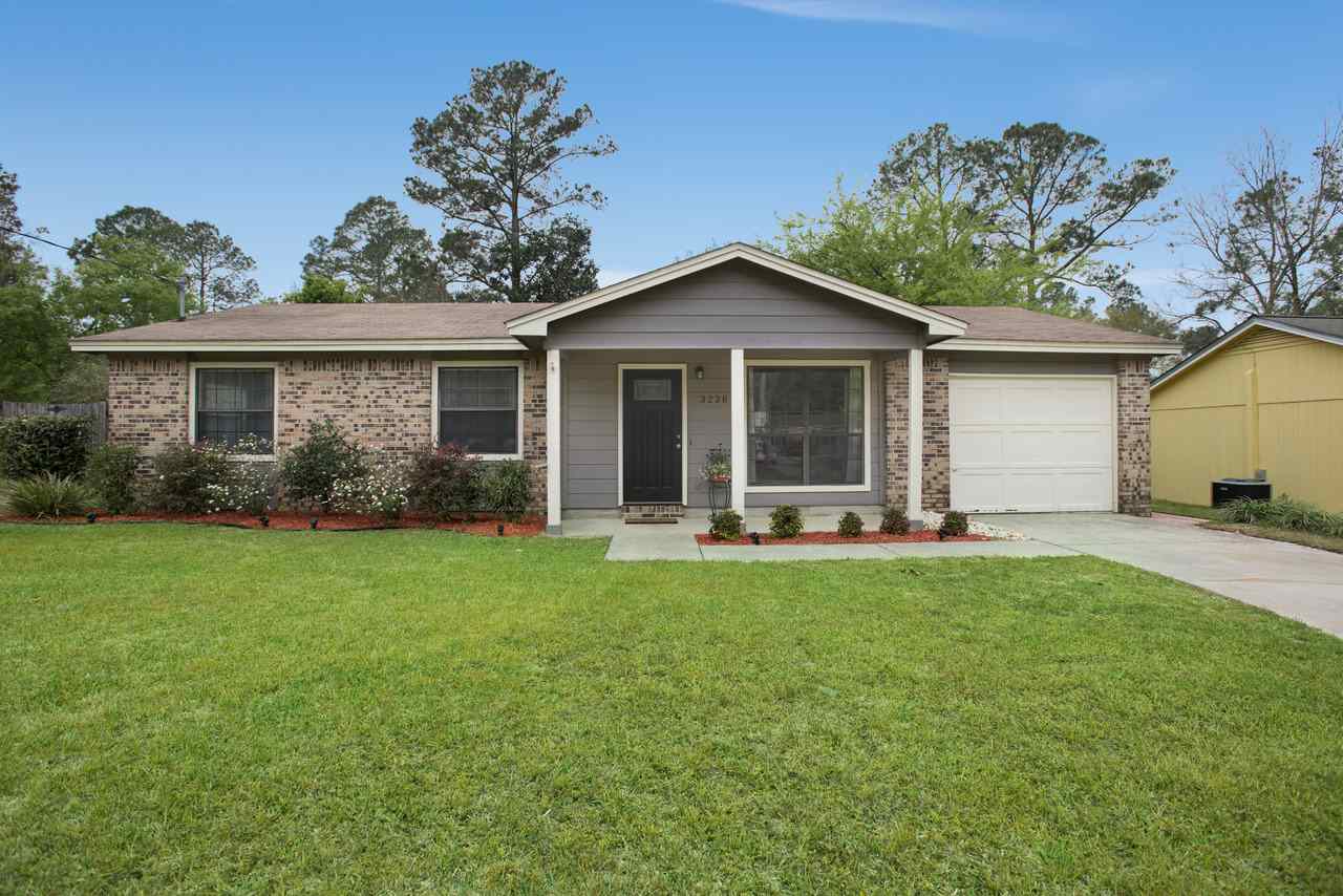 A suburban home featuring a well-maintained lawn and a welcoming front porch.