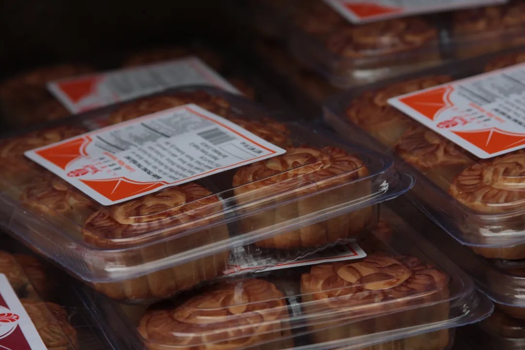Packaged mooncakes with a decorative top, stacked for sale at the San Francisco Autumn Moon Festival.