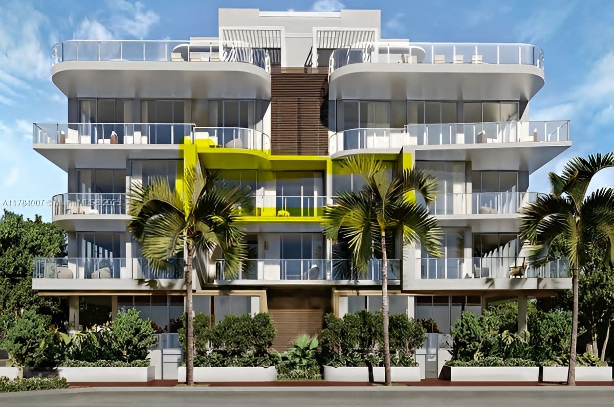 Ocean Park South Beach building with glass balconies, a bright yellow facade detail, and palm trees.