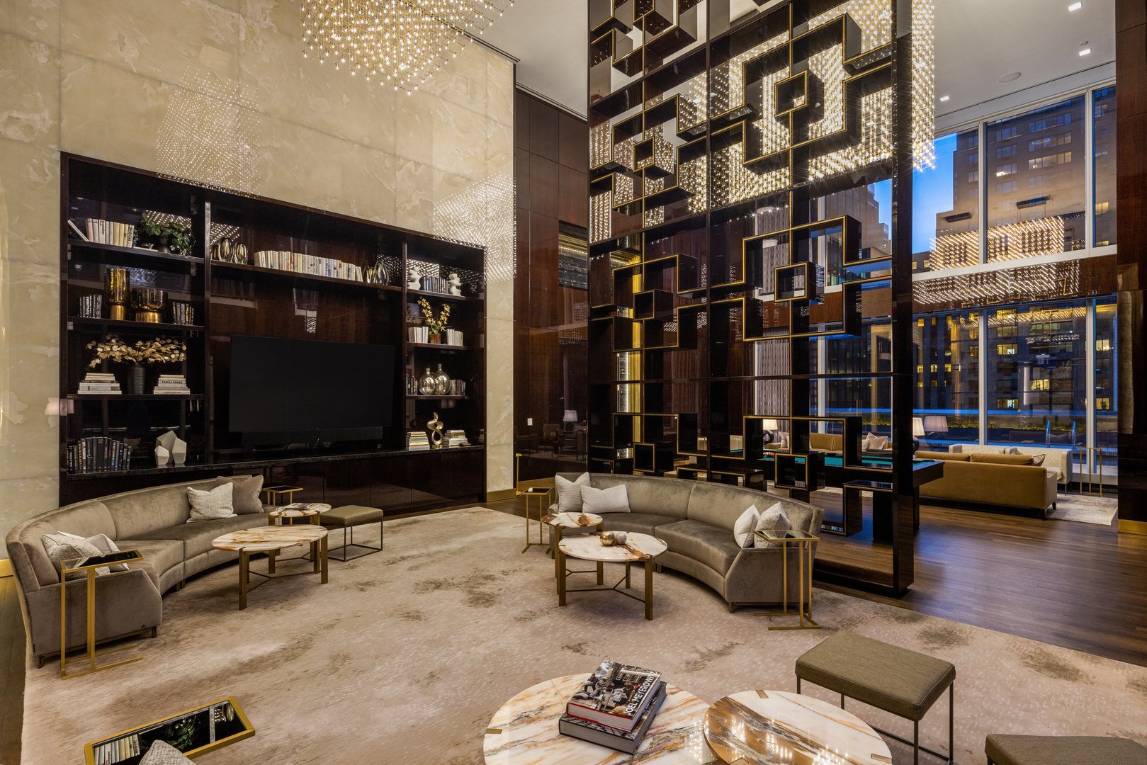 Luxury lounge with curved sofas, illuminated geometric shelving, and floor-to-ceiling windows.