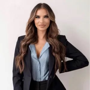 Moyra Sumic in a black blazer and blue striped blouse