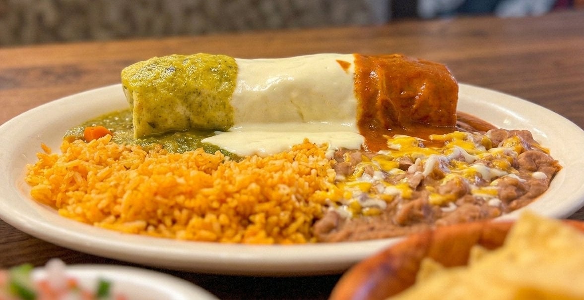 Platter of authentic Mexican food at Green Iguana Mexican Restaurant in St. George, Utah, featuring Chile Verde, rice, and beans.