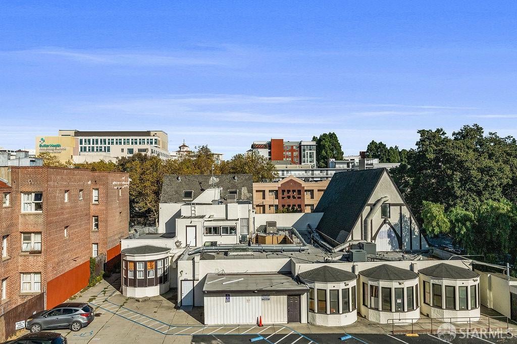 Elevated view of Oakland buildings, including a distinctive steep A-frame roof and paved parking area.