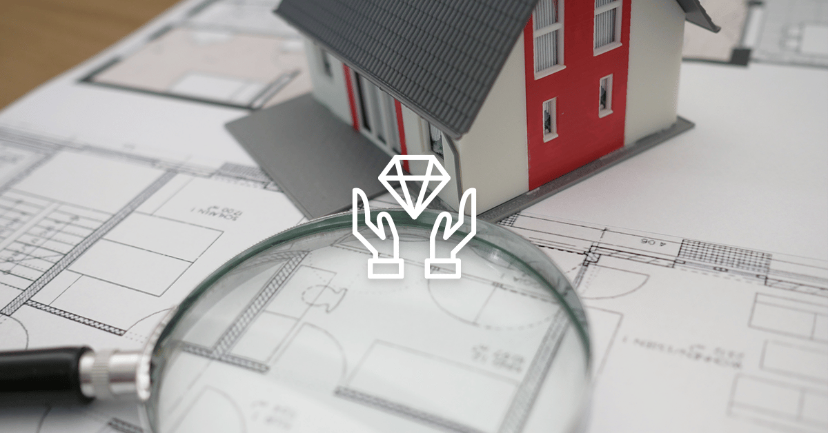 Hands holding a diamond over a model house, floor plans, and a magnifying glass.