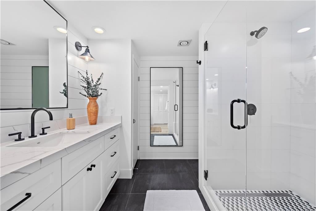 Modern bathroom with a white vanity, black fixtures, and a glass-enclosed shower.
