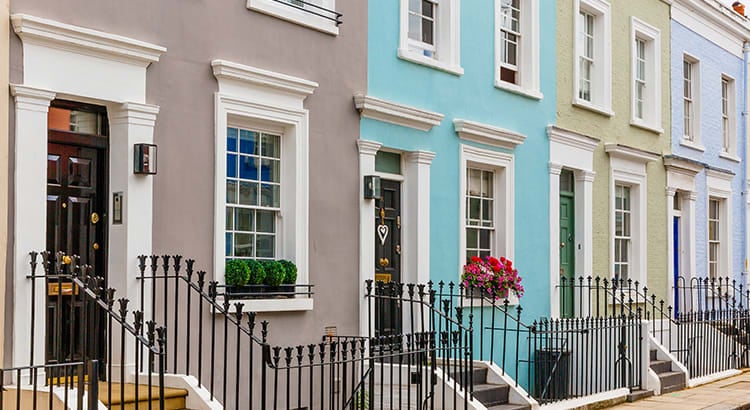 A row of colorful, charming terraced townhouses in a city center.