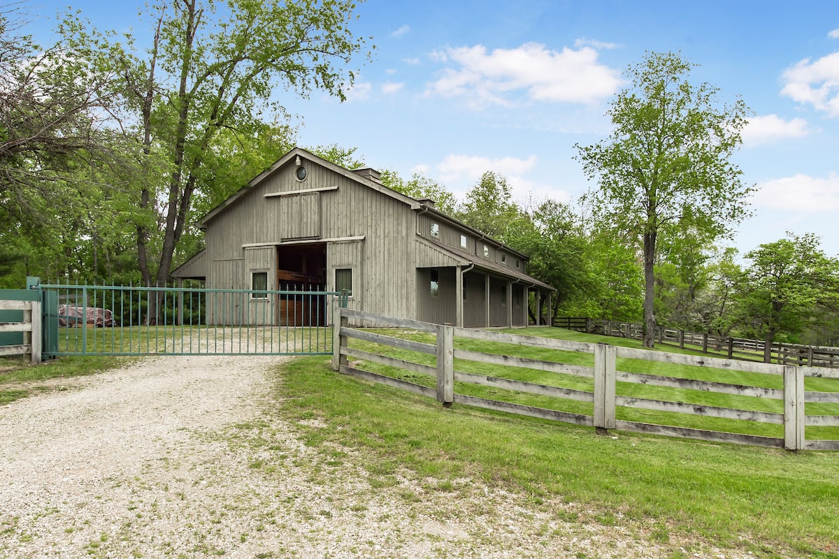 small horse barn in delaware county with wood board fencing