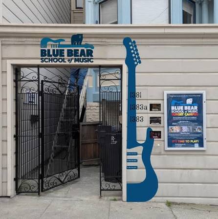 Blue Bear School of Music storefront entrance with guitar mural signage
