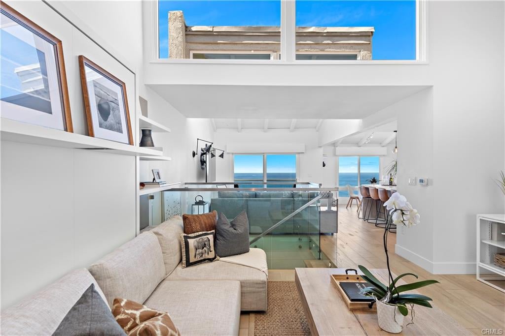 Living room with a cream sectional sofa and ocean views through large windows.