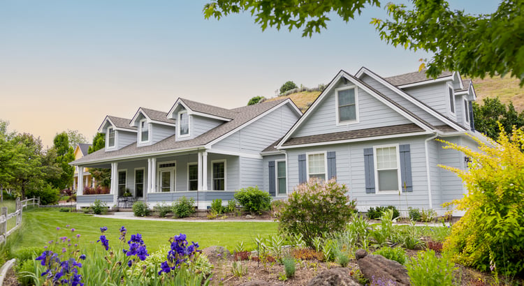 An image of a beautiful house with a well-manicured lawn and flowers, showcasing a picturesque residential property.