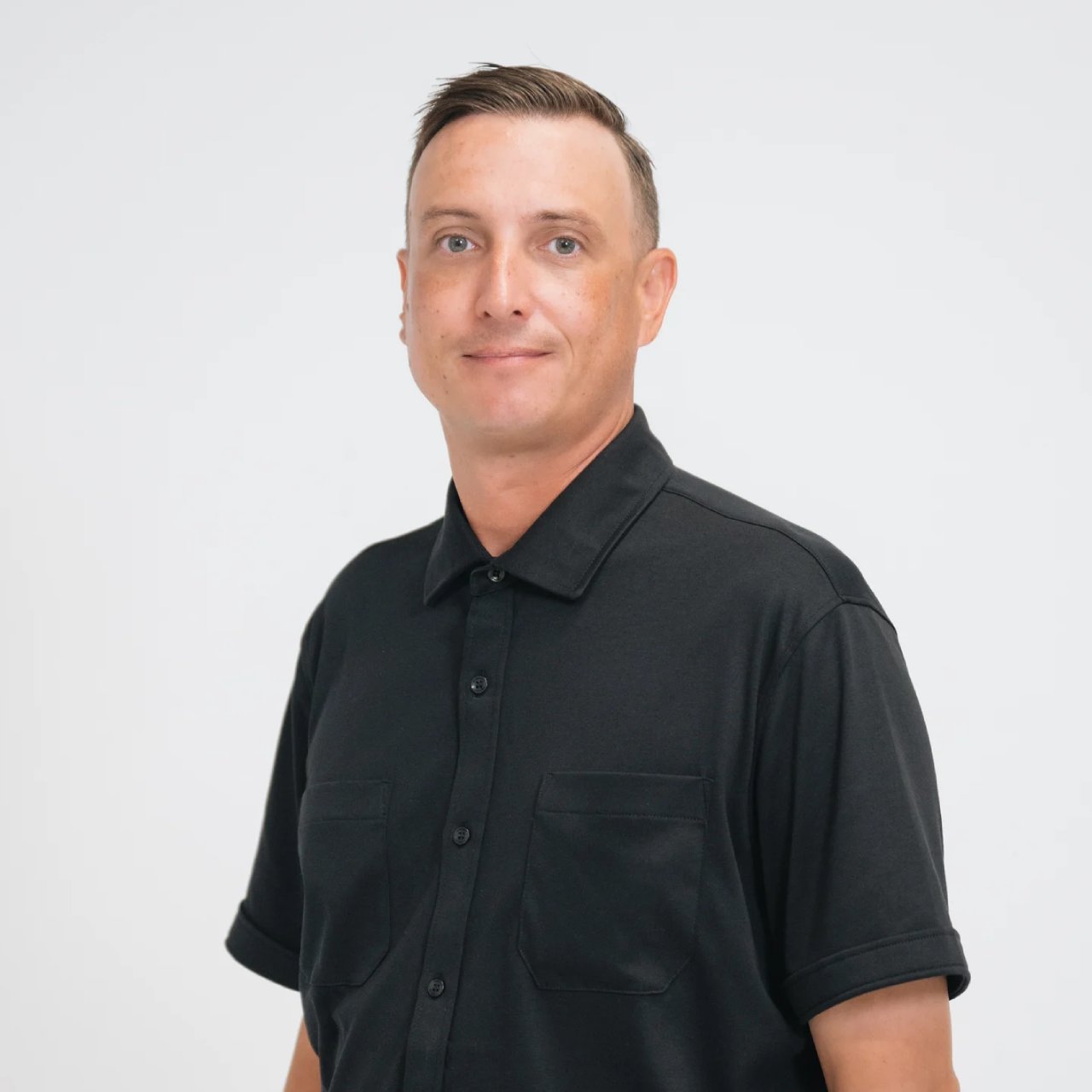 Kyle Owens in a black short-sleeved collared shirt.