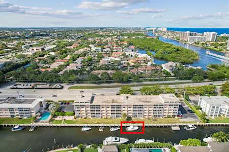 Aerial view of East Boca Raton neighborhoods, a boat-lined canal, and the coastline.