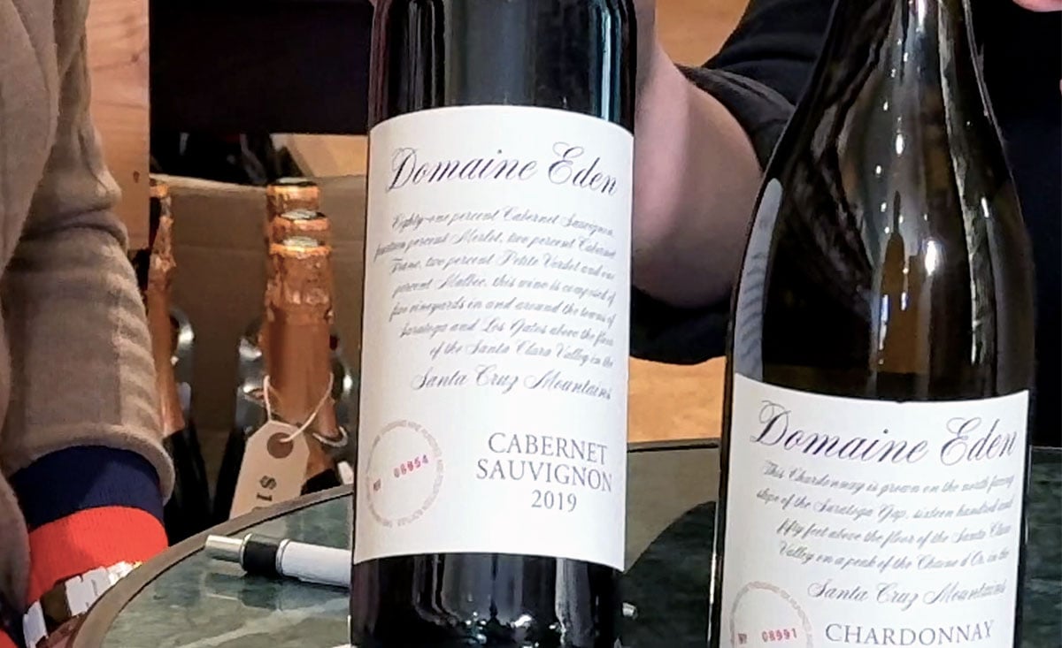 Two wine bottles on a table: one labeled "Domaine Eden Cabernet Sauvignon 2019" and the other "Domaine Eden Chardonnay."