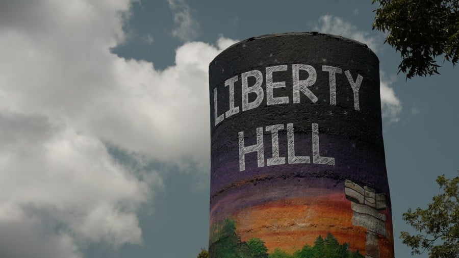 Liberty Hill water tower with a colorful painted landscape beneath its name.