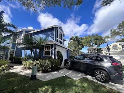 Modern two-story house with dark trim, landscaped yard, and a black SUV in the driveway.