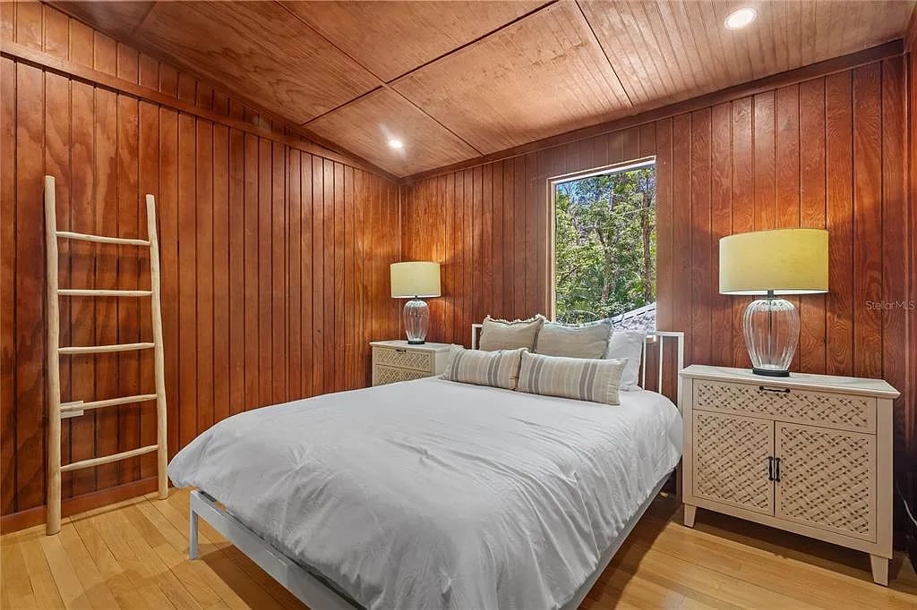 Cozy wooden bedroom with white bedding