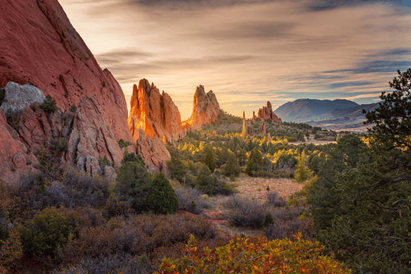 Red sandstone formations at Garden of the Gods beneath a warm sunset sky.