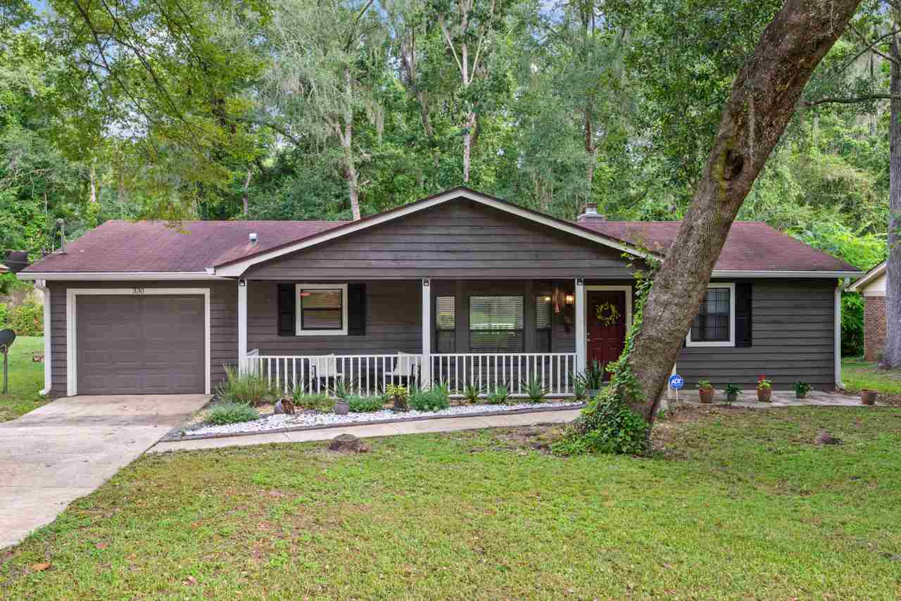 A cozy home nestled among trees in a serene wooded neighborhood setting.