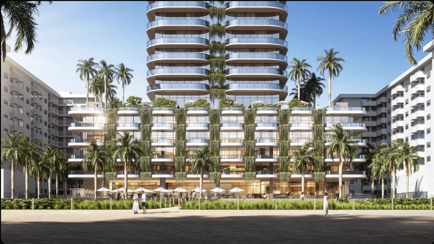 Rounded twin-tower condominium complex rising behind palm-lined low-rise buildings.
