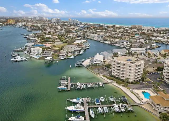 Aerial view of waterfront homes, marina docks, and condominiums beside the Gulf.