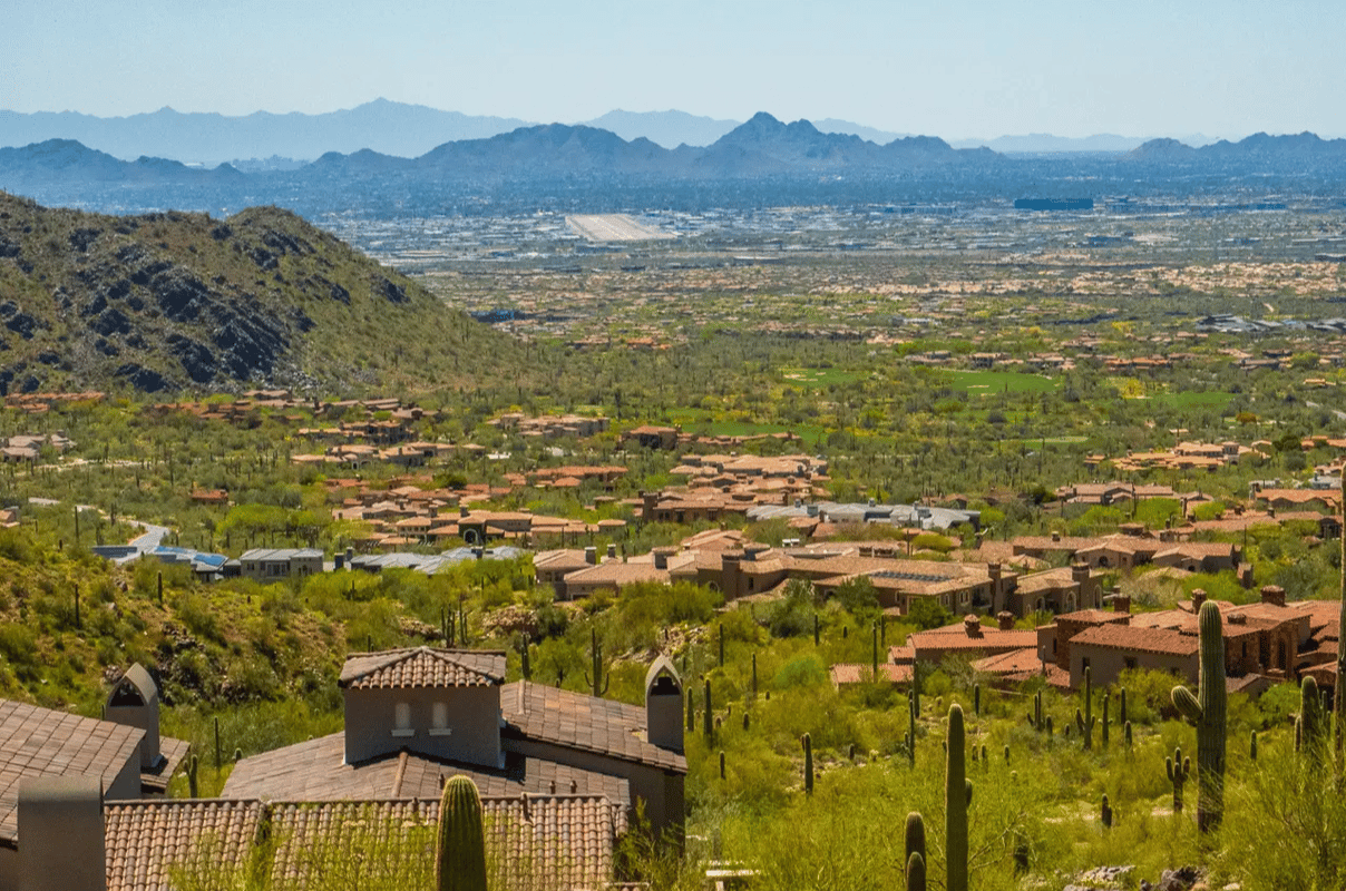 Phoenix Valley suburbs beneath desert mountains, viewed from a hillside neighborhood.