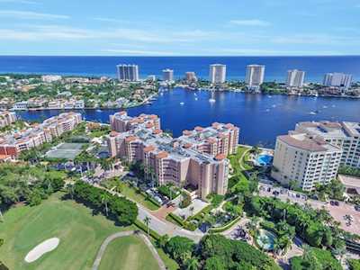 Aerial view of East Boca waterfront condos, a golf course, and the ocean beyond.