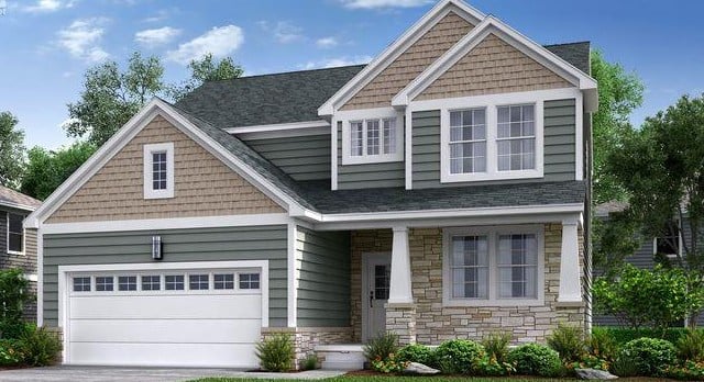 Two-story green house with beige gables, stone entry accents, and an attached two-car garage.