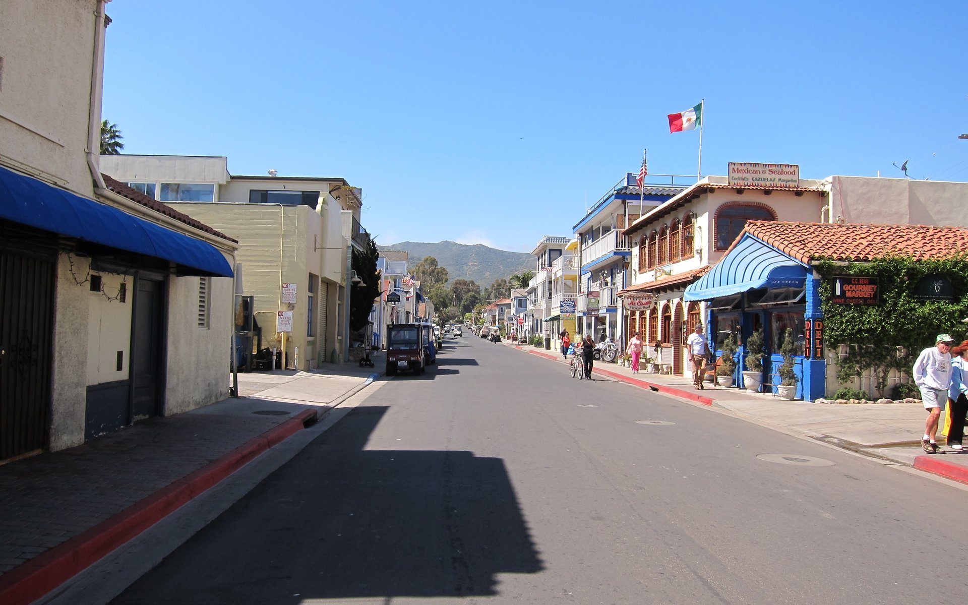 An Avalon commercial street with shops and island hills beyond