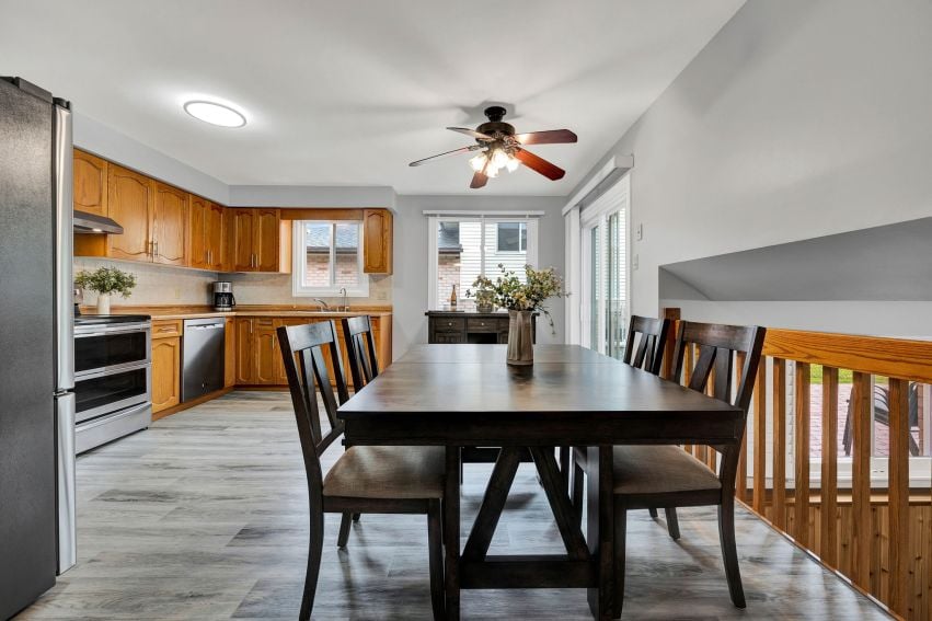 Kitchen and dining area with warm wood cabinets, a dark table, and sliding glass doors.