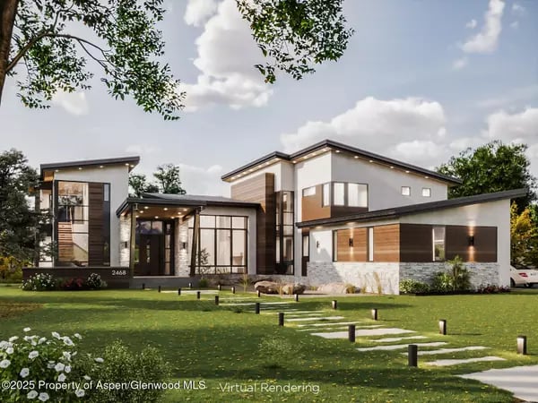 Modern two-story home with large windows, wood accents, and a stepping-stone path across the lawn.
