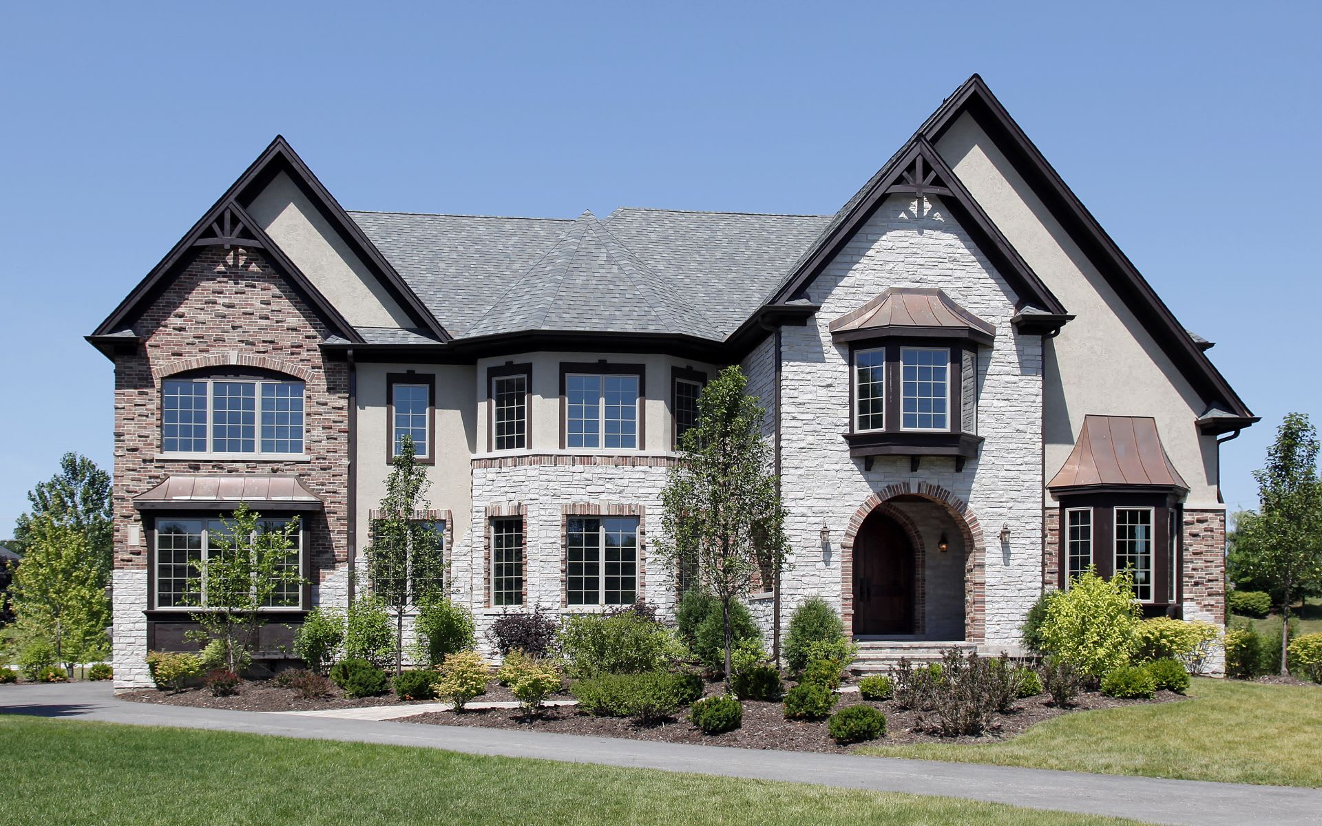 A large house with a lot of windows and a driveway in front of it.