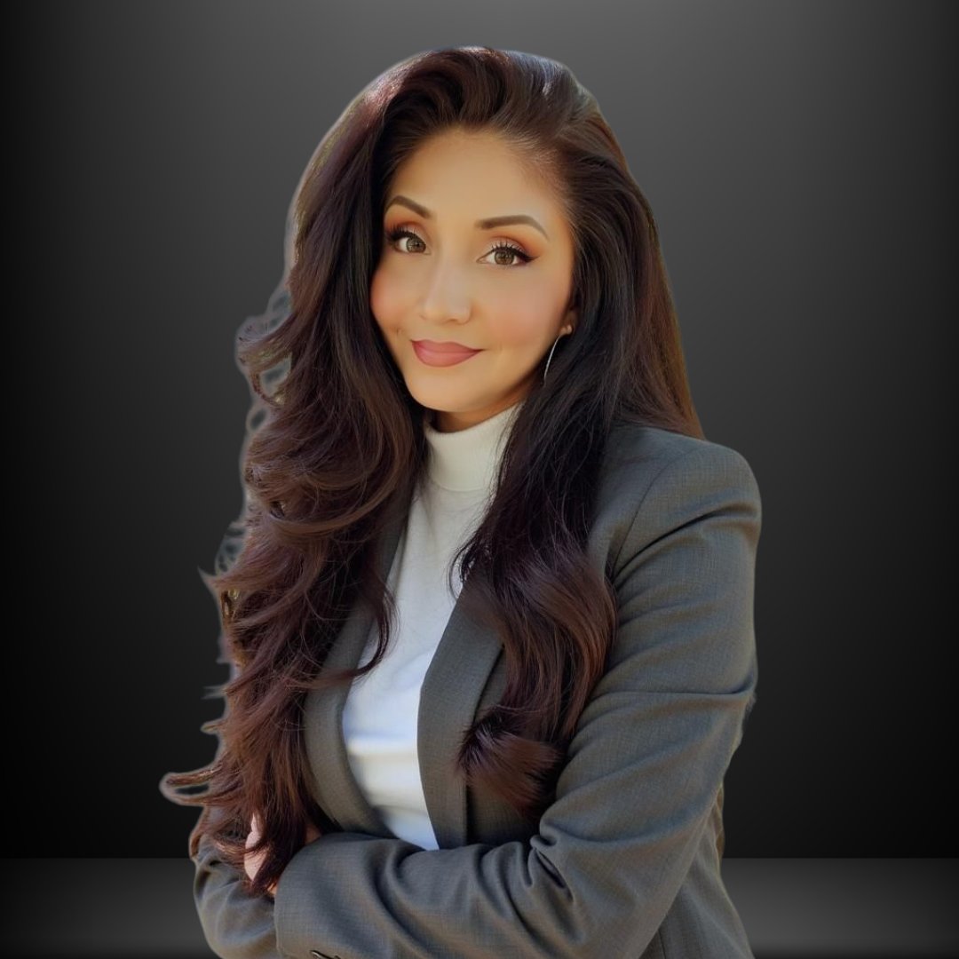 Gabriela Moreno in a gray blazer, smiling with her arms crossed.