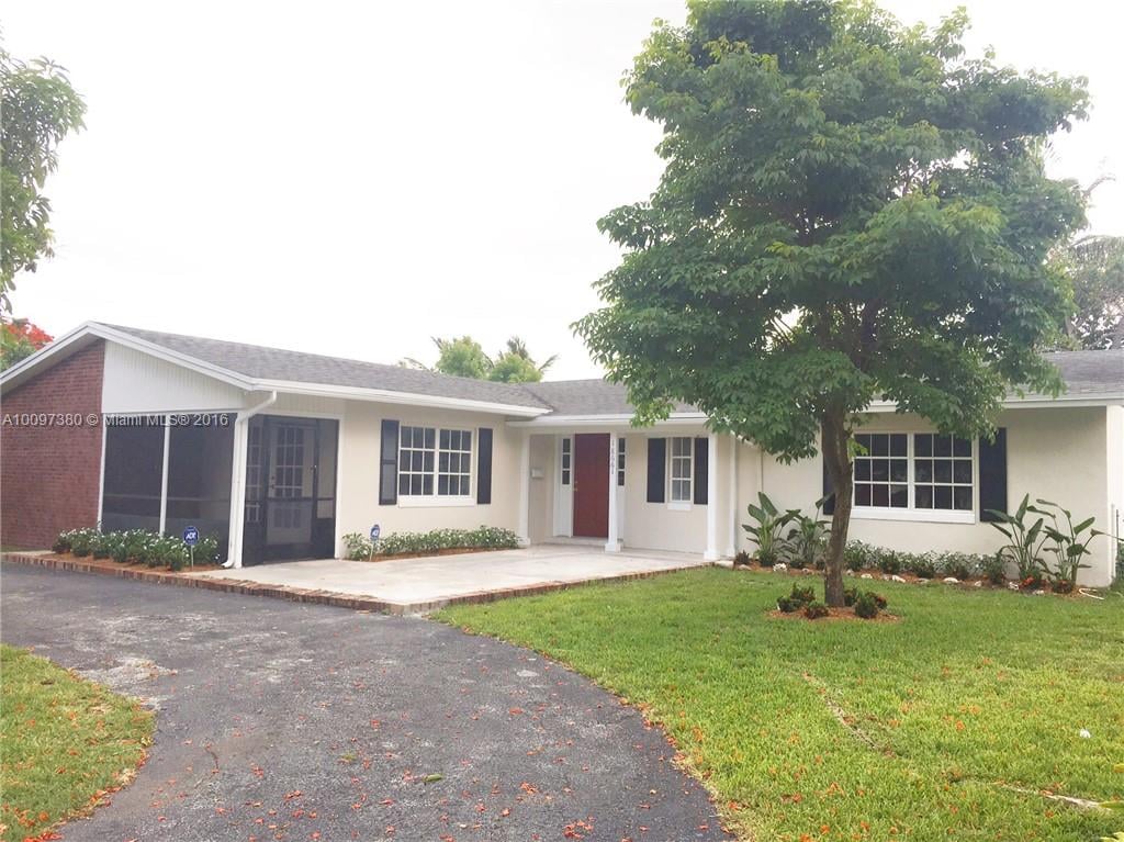Single-story home with a screened porch, red front door, and large tree in the front lawn.