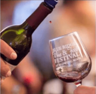 Wine being poured into a glass marked Blue Ridge Wine & Food Festival.