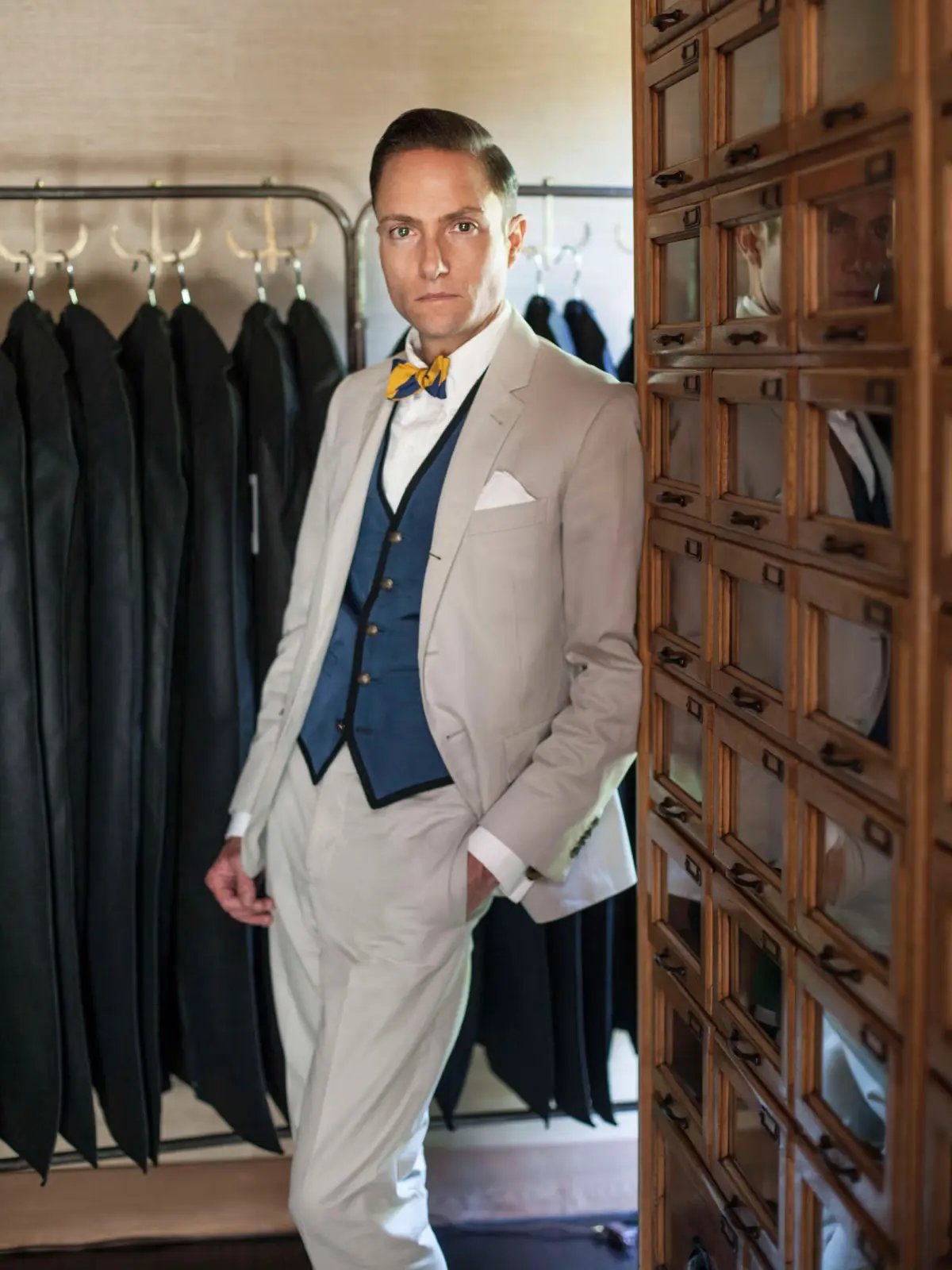 Ken Fulk, looking sharp in a beige suit paired with a striking blue vest and a yellow bow tie